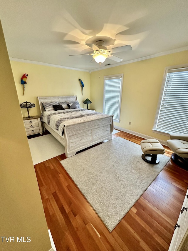 bedroom with wood finished floors, a ceiling fan, and crown molding