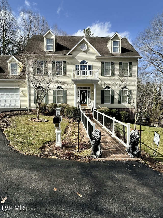 view of front facade with a garage, a fenced front yard, a front yard, and a balcony