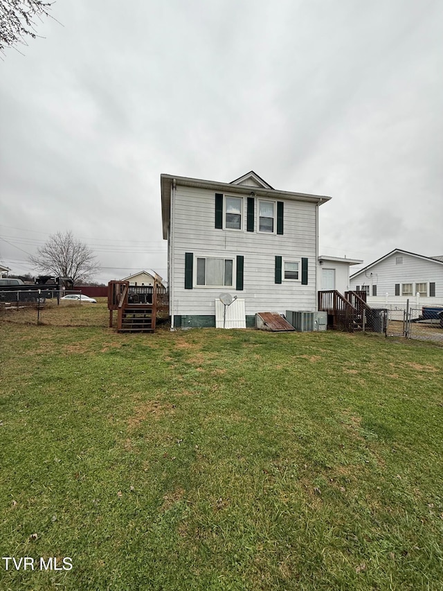 rear view of house with a yard and fence