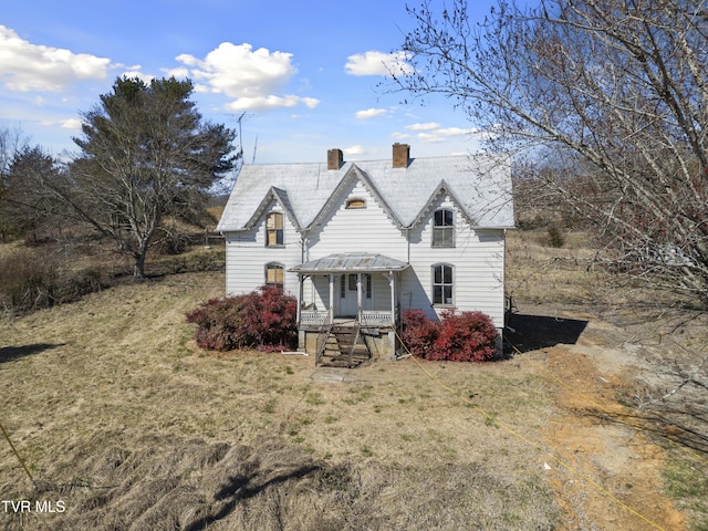 view of front of house with a chimney and a front yard