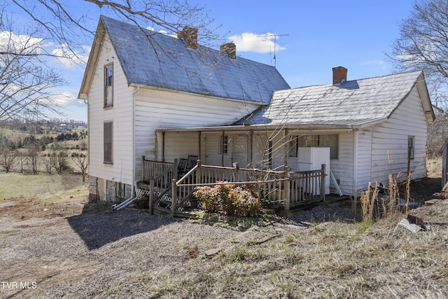 rear view of house featuring a chimney