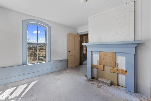 unfurnished living room with concrete flooring and a fireplace