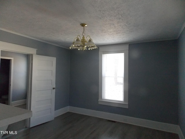 unfurnished dining area with dark wood-style flooring, ornamental molding, a textured ceiling, a chandelier, and baseboards