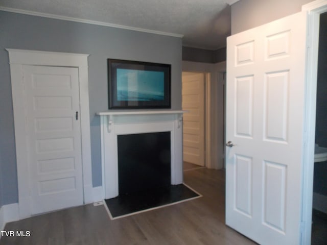 unfurnished living room featuring dark wood-type flooring, a fireplace, and crown molding