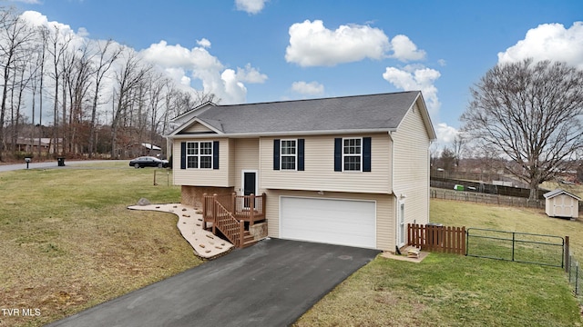 bi-level home featuring a garage, a front yard, driveway, and fence