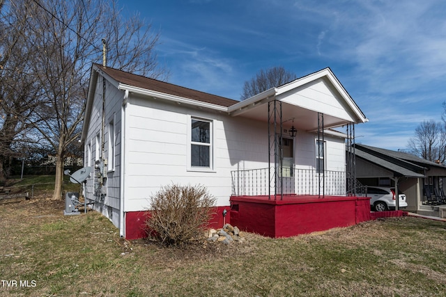 view of front of home with an attached carport and a front yard