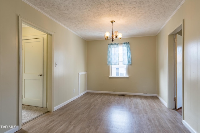 204 Johnston Ave, Bristol, TN 37620 - spare room featuring light wood-type flooring, an inviting chandelier, ornamental molding, and a textured ceiling