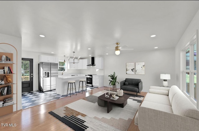 living area with a ceiling fan, plenty of natural light, light wood-style flooring, and recessed lighting