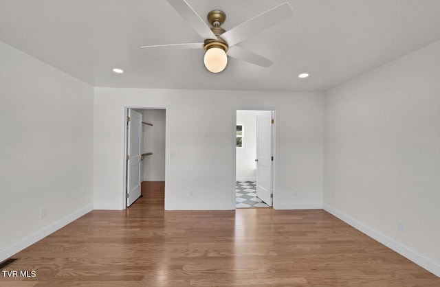 spare room featuring a ceiling fan, recessed lighting, light wood-style flooring, and baseboards