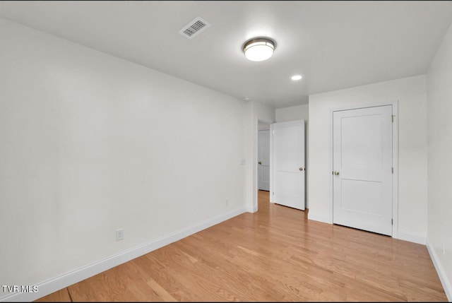 unfurnished bedroom with visible vents, light wood-style flooring, and baseboards