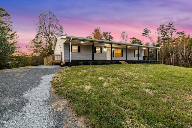 view of front of home featuring driveway, a porch, and a yard