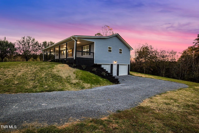 view of home's exterior with driveway, a porch, a lawn, and an attached garage