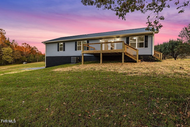 back of house at dusk with central AC, a lawn, stairway, and a wooden deck