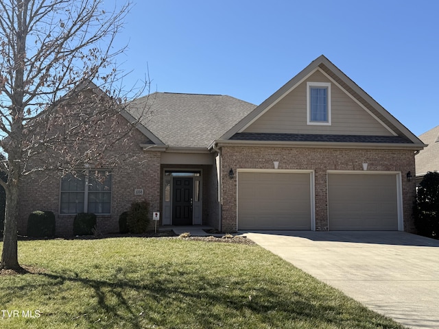 view of front of house with a garage, driveway, a shingled roof, a front yard, and brick siding