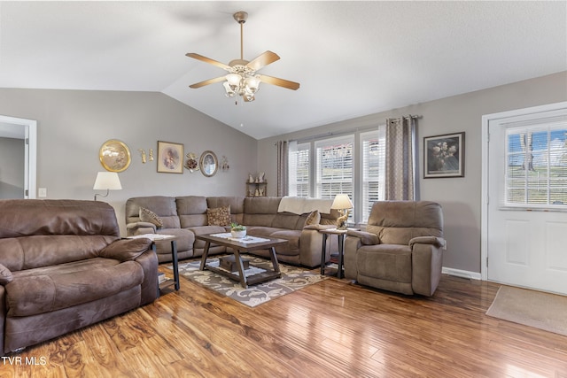 living area featuring vaulted ceiling, ceiling fan, wood finished floors, and baseboards