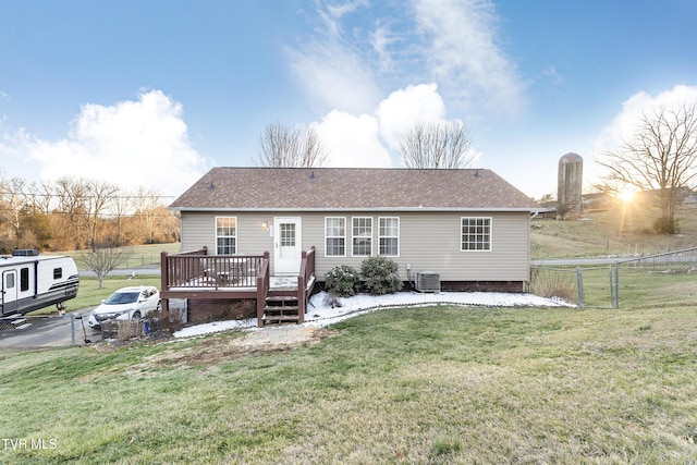 rear view of property featuring a yard, cooling unit, fence, and a deck