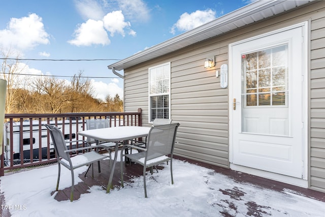 snow covered deck with outdoor dining area