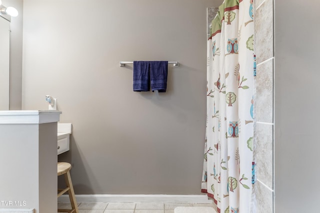 bathroom with baseboards, curtained shower, and tile patterned floors