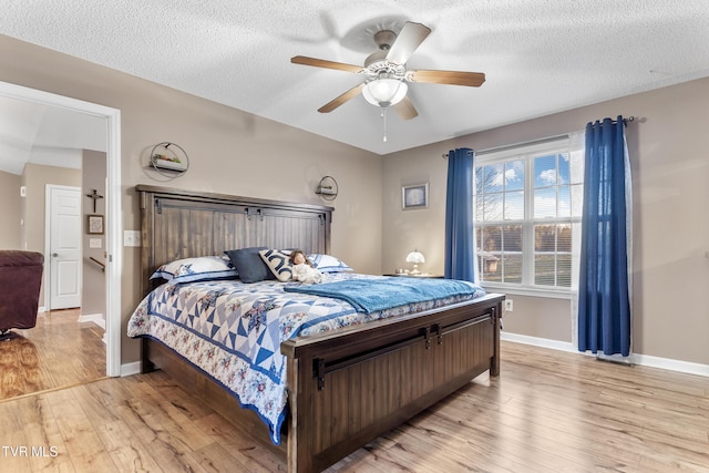 bedroom featuring a textured ceiling, light wood finished floors, and baseboards