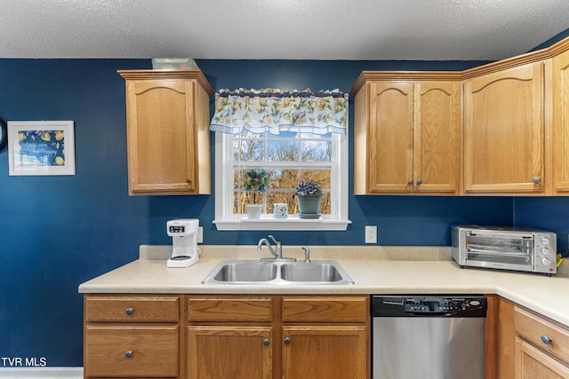 kitchen featuring a textured ceiling, a toaster, a sink, light countertops, and stainless steel dishwasher