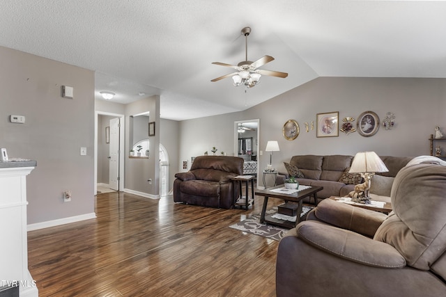 living room with ceiling fan, vaulted ceiling, a textured ceiling, wood finished floors, and baseboards