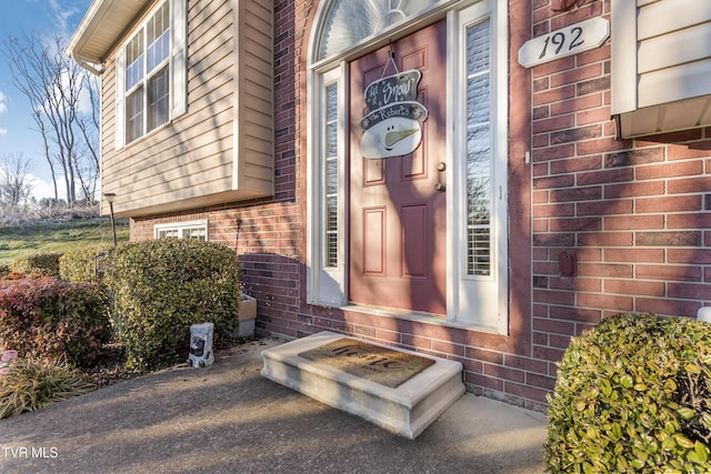 view of exterior entry featuring brick siding