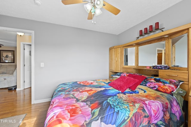 bedroom featuring a ceiling fan, dark wood finished floors, a textured ceiling, and baseboards
