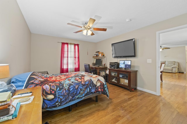 bedroom featuring wood finished floors, a ceiling fan, and baseboards