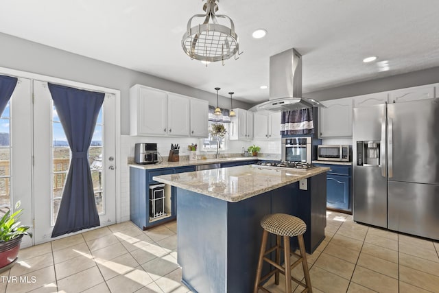 kitchen with island range hood, white cabinets, a center island, blue cabinets, and stainless steel appliances