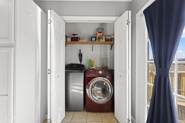laundry room featuring washing machine and dryer, laundry area, and light tile patterned floors
