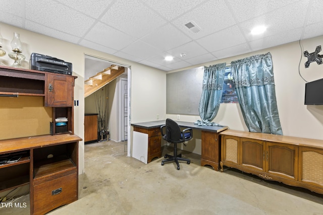 office area with a drop ceiling, visible vents, and unfinished concrete floors