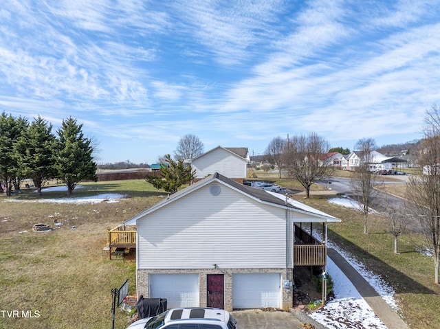 view of property exterior featuring an attached garage, a deck, and concrete driveway
