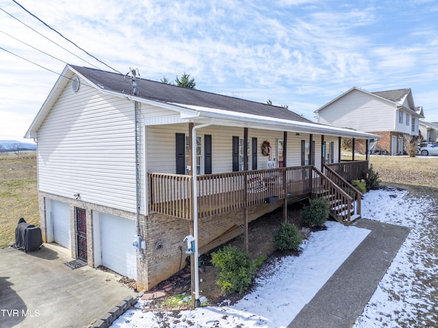 view of front of house featuring covered porch, driveway, and a garage