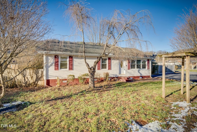 ranch-style home with a front yard and fence