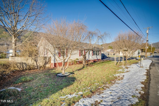 view of front of house featuring fence and a front lawn