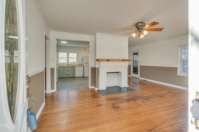 unfurnished living room featuring light wood-type flooring, a fireplace, and baseboards