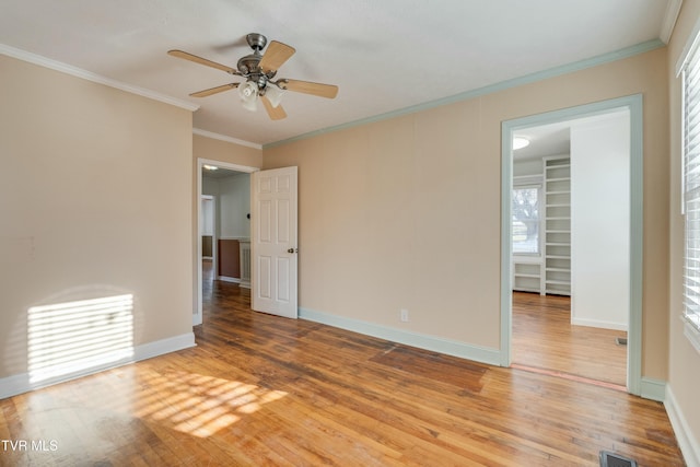 spare room with visible vents, ornamental molding, and wood finished floors