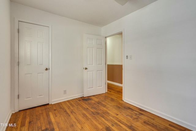 unfurnished bedroom with wood finished floors and baseboards