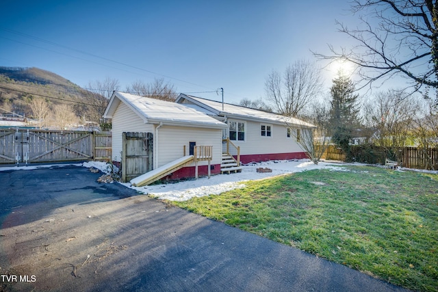 back of property featuring a yard, a gate, and fence