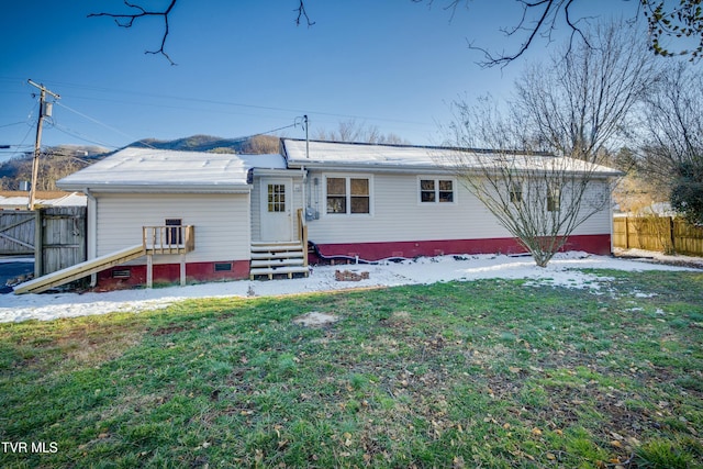 view of front of home with entry steps, crawl space, fence, and a front yard