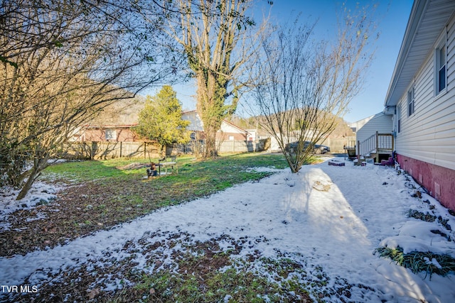 snowy yard with a fenced backyard