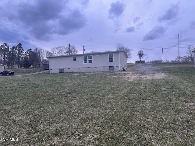 exterior space with crawl space, central AC, and a lawn