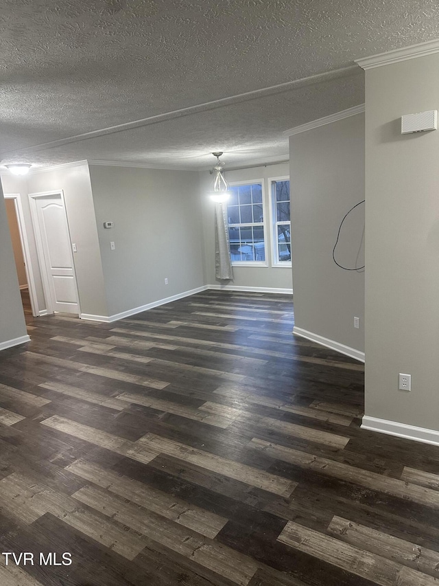 empty room with dark wood-style flooring, crown molding, a textured ceiling, and baseboards