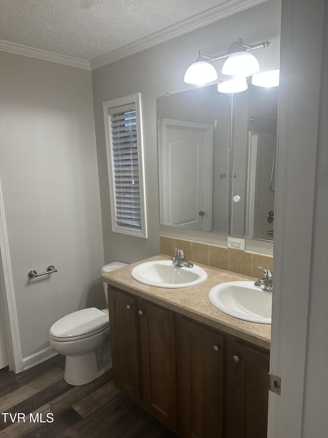 bathroom with toilet, a textured ceiling, a sink, and wood finished floors