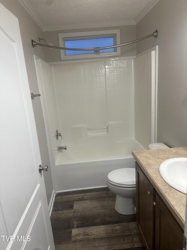 bathroom featuring toilet, wood finished floors, tub / shower combination, a textured ceiling, and vanity