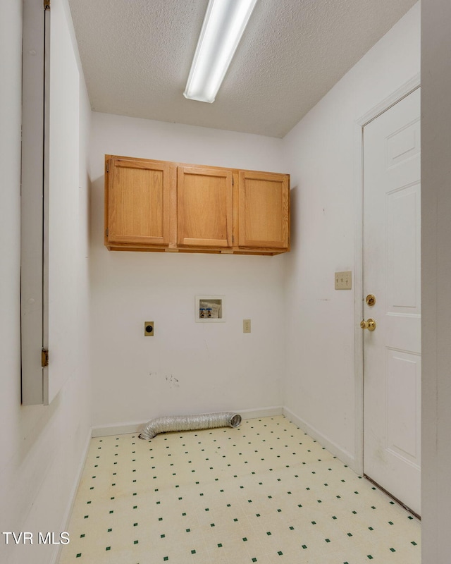 clothes washing area with cabinet space, baseboards, a textured ceiling, washer hookup, and electric dryer hookup