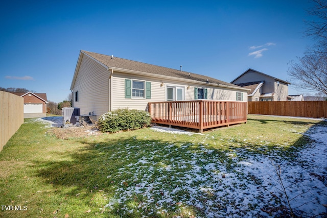 rear view of house with a yard, fence, and a wooden deck