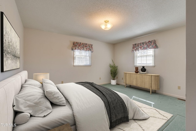 carpeted bedroom with a textured ceiling and baseboards