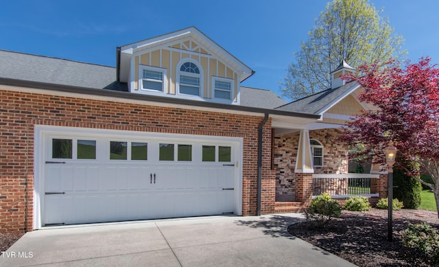 view of front of house with a porch, driveway, a shingled roof, and brick siding