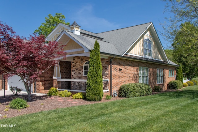 view of property exterior with a shingled roof, a lawn, a porch, brick siding, and a garage